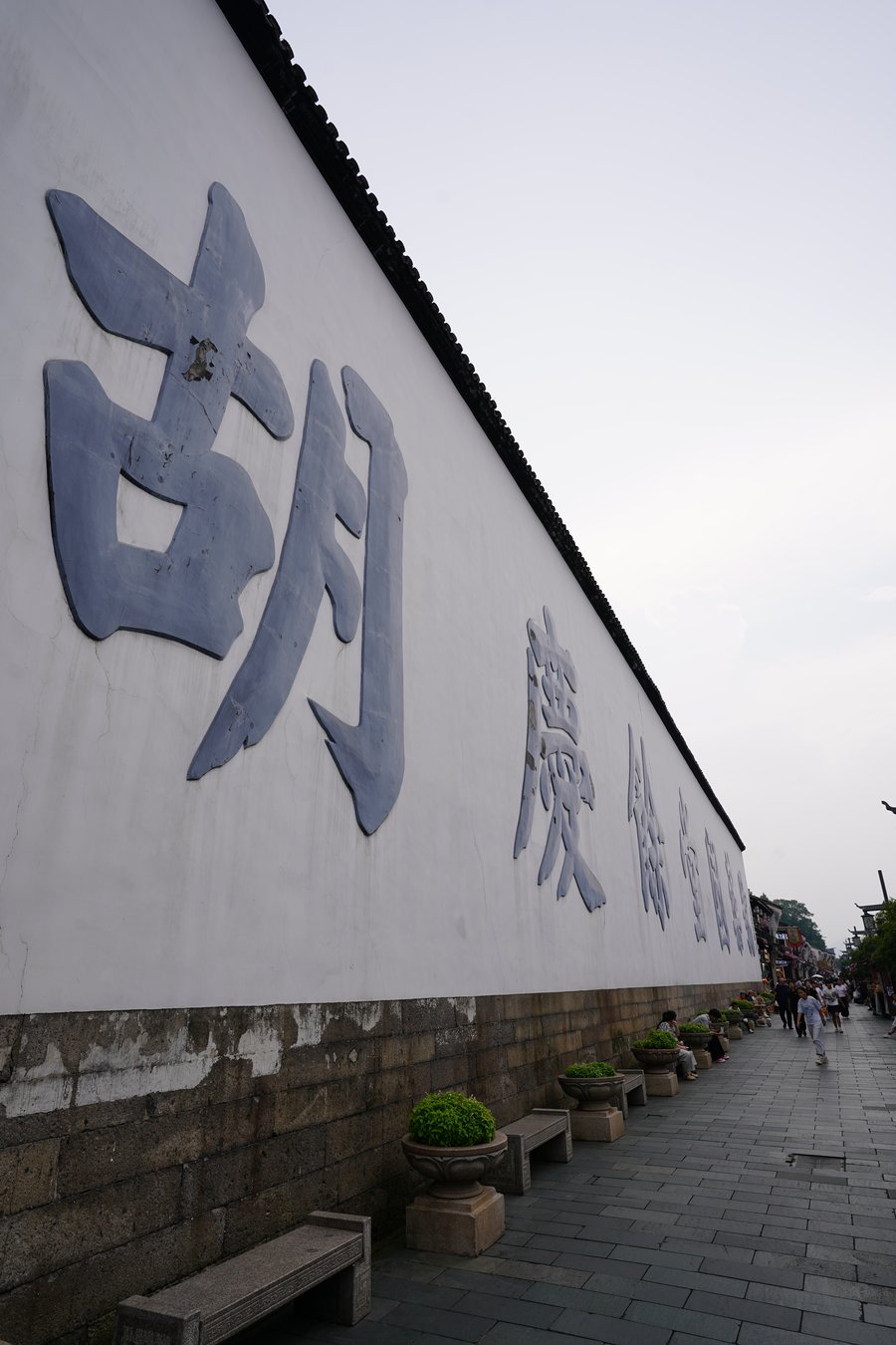 Large carved characters on the whitewashed wall of a historic Qinghefang pharmacy