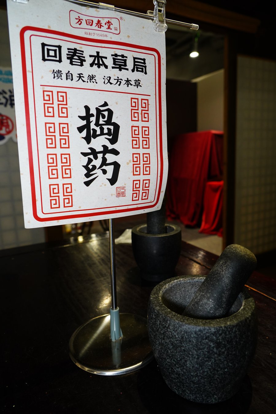 A stone mortar and pestle beside a hand-written medicine sign