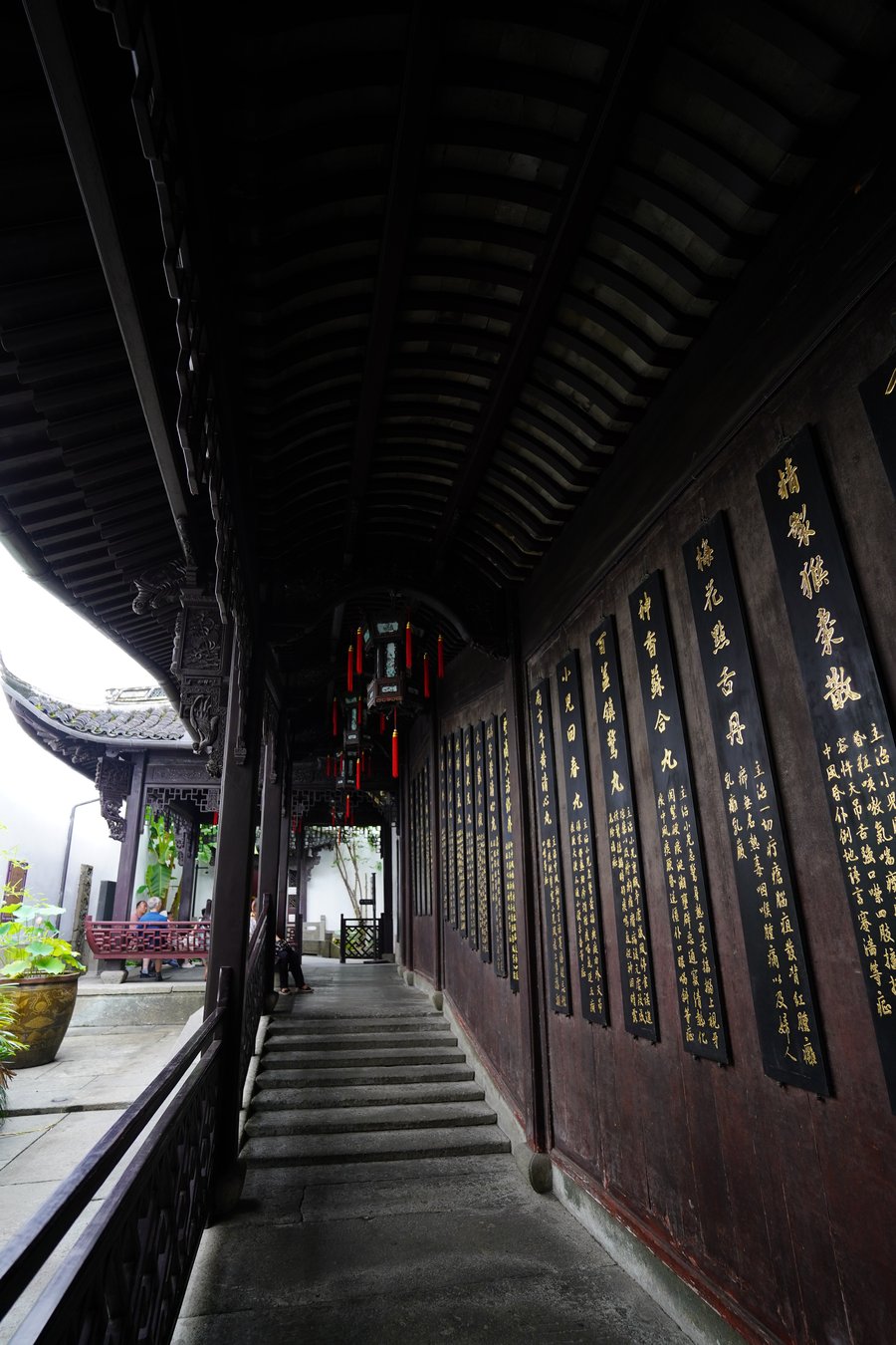A covered timber corridor lined with gilded pharmacy plaques