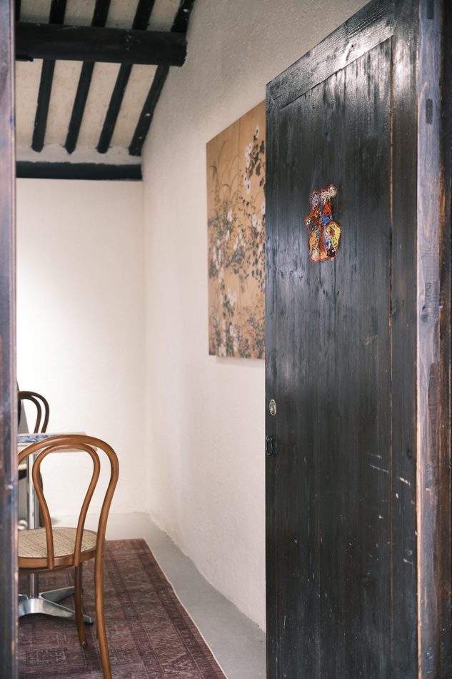 A dark timber interior with an old door and a bentwood chair