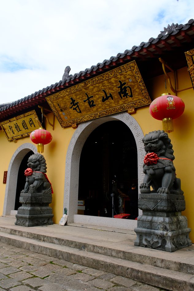 The gate of Nanshan Temple with stone lions and red lanterns