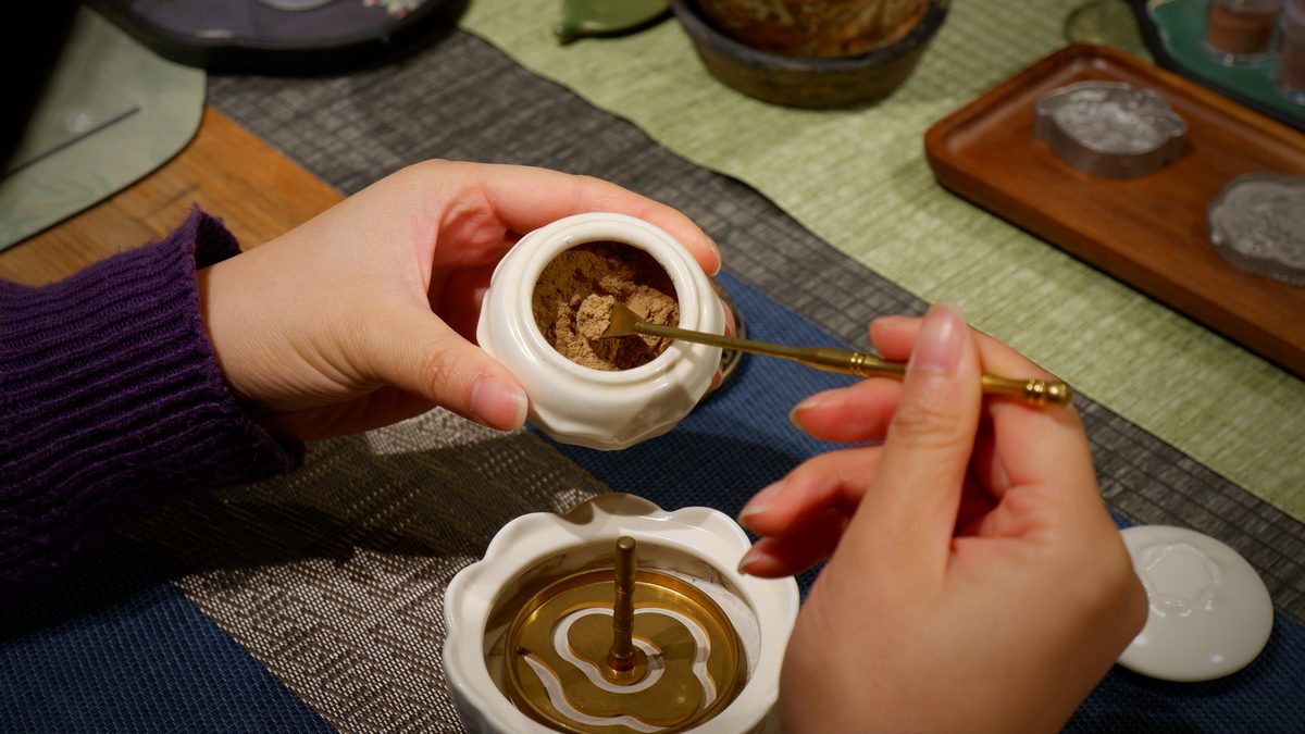 A spiral of powdered incense formed inside a ceramic bowl