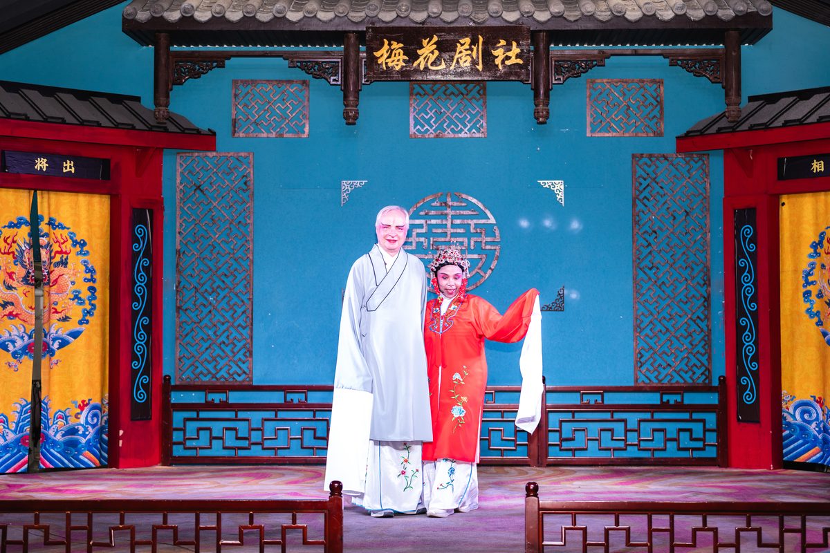 Two performers in costume standing together on stage