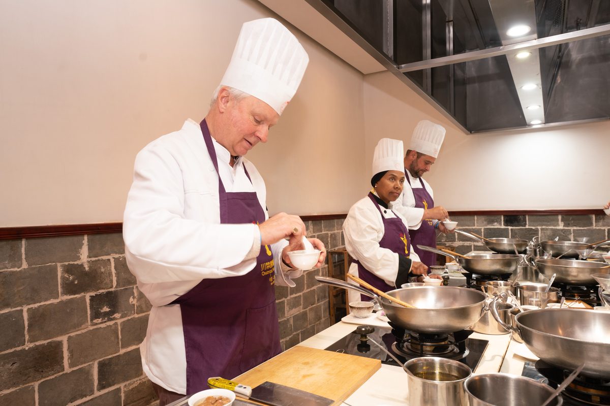 A chef working at a stainless counter in the teaching kitchen