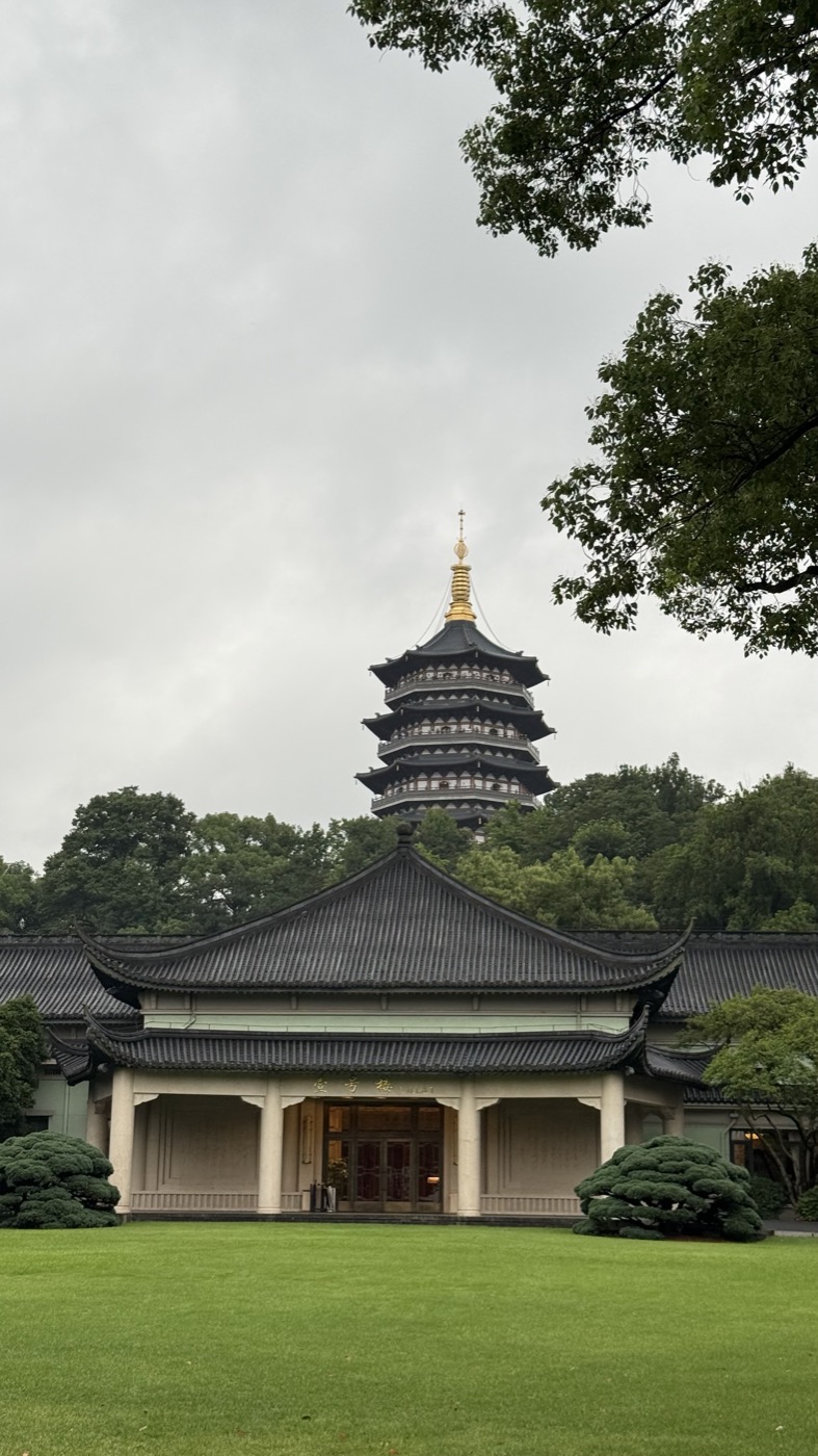 The colonnaded entrance of Zhejiang Xizi Hotel with Leifeng Pagoda rising behind it
