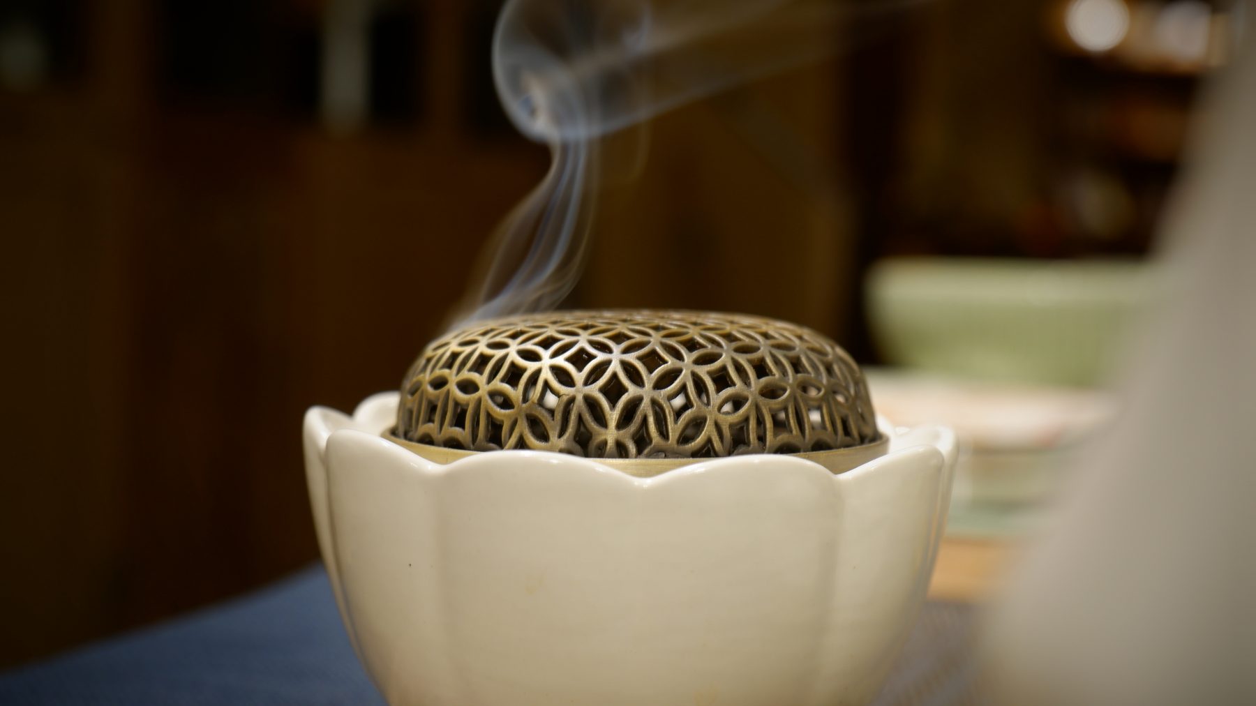 A lidded ceramic censer with a thin line of incense smoke rising