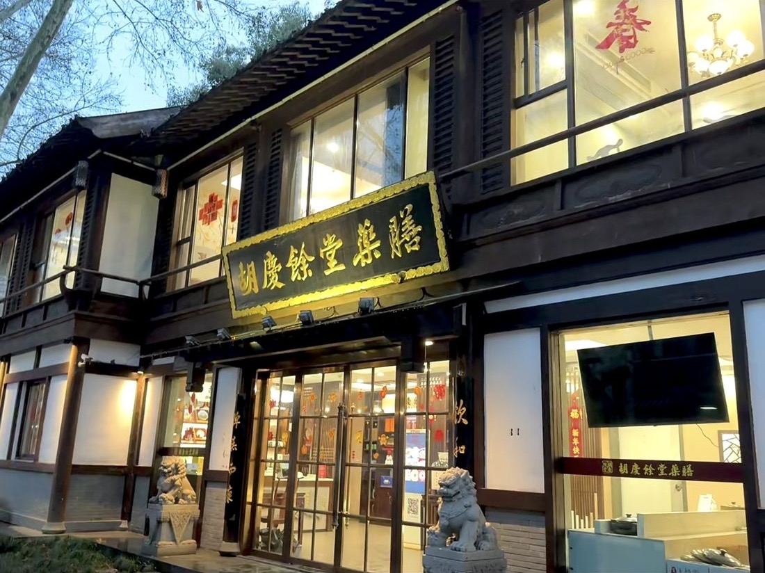 The lit shopfront of the Hu Qing Yu Tang pharmacy in Hangzhou's old quarter
